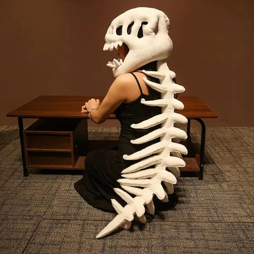 A white dinosaur skeleton plush costume resembling a large rib cage is displayed on a wooden table.