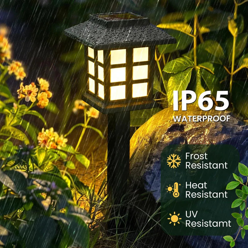 A close-up of an IP65 waterproof solar pathway light fixture illuminating a garden setting during rain.