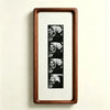 A framed photo strip featuring five portraits of a couple, displayed in a walnut wood frame.