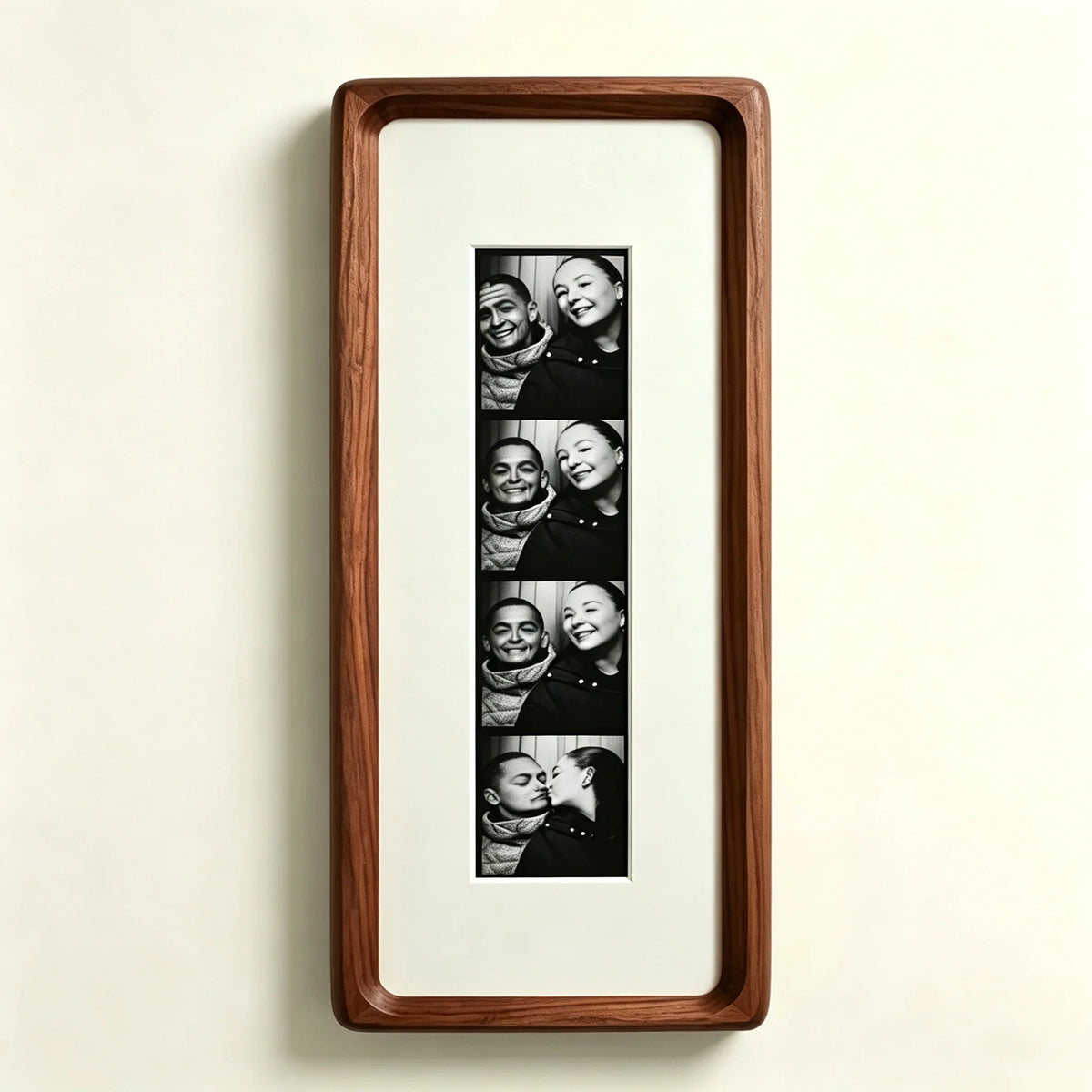 A framed photo strip featuring five portraits of a couple, displayed in a walnut wood frame.
