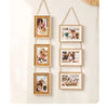 A vertical display of five wooden photo frames with gold string hangers, showcasing various pictures.