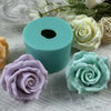 A light blue silicone mold shaped like a rose flower is displayed on white fabric with other floral elements.