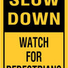 A yellow and black sign instructing drivers to Slow Down and Watch for Pedestrians.
