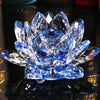 A brilliant blue crystal lotus flower ornament resting on a dark reflective surface.