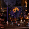 A dark wooden surface features a Halloween themed advent calendar box with a grid of spooky icons and surrounding decorative 