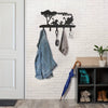 Black metal key hooks mounted on a white brick wall for decorative organization