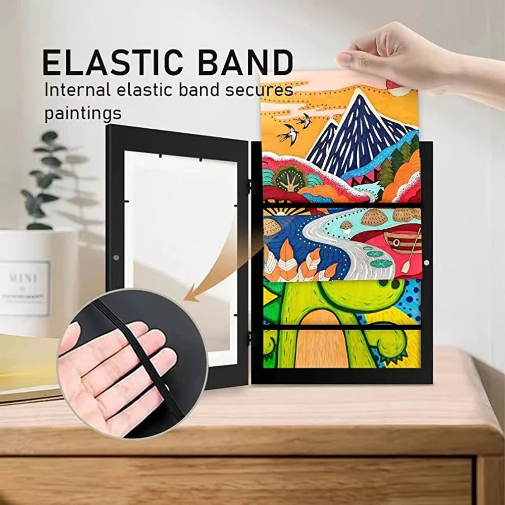 An elastic band secures paintings inside a magnetic front opening art display frame.