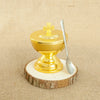 A gold-plated Orthodox censer with bells resting on a wooden slice.