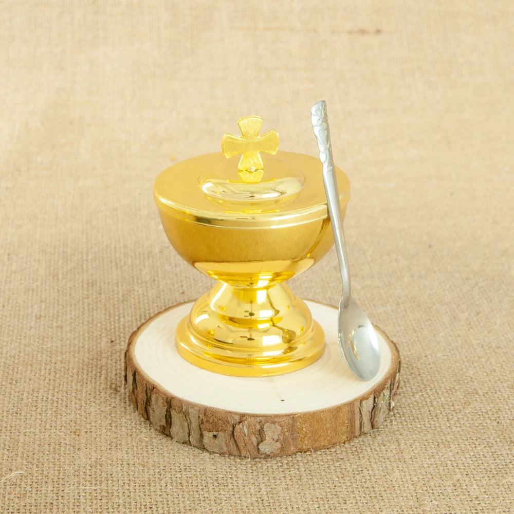 A gold-plated Orthodox censer with bells resting on a wooden slice.