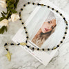 A green crystal rosary necklace with a Saint Jude and Virgin Mary cross pendant displayed on a white background.