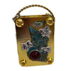 A small gold-toned metal press kit with a wire loop, featuring a pressed blue leaf and a red bead.