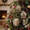 A festive Christmas tree decorated with miniature wooden cabin ornaments and red ribbon.