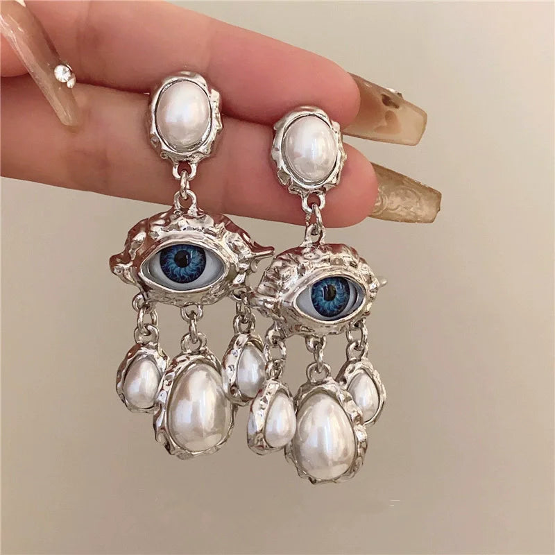 Silver pearl drop earrings featuring a devil's eye gemstone design.