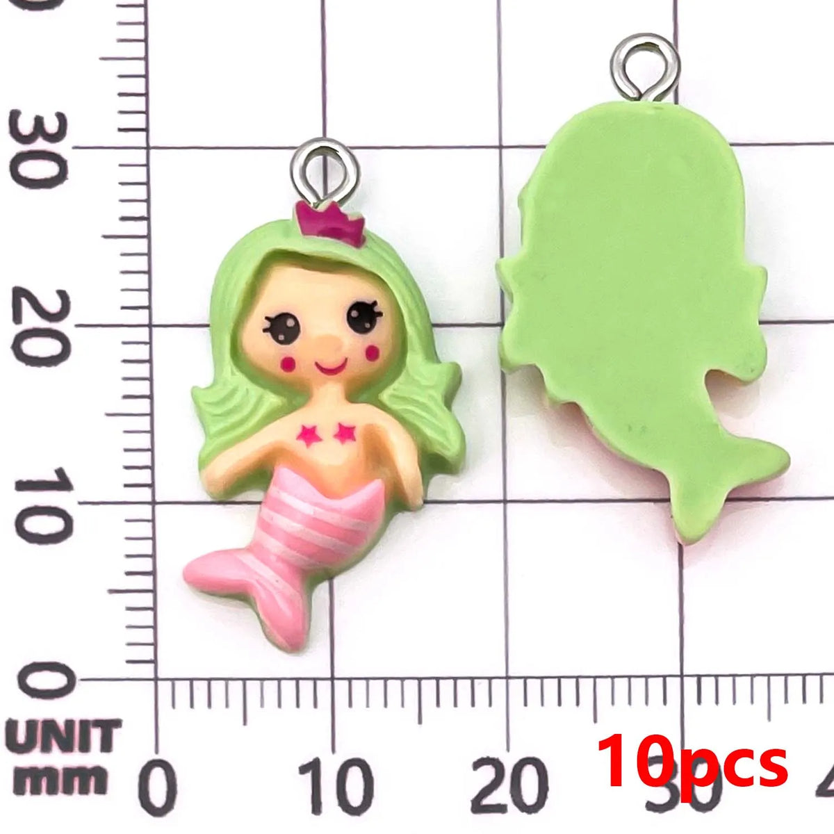 Green resin mermaid princess charm and leaf shape displayed against a millimeter ruler.