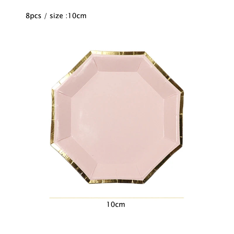 A pink, gold-edged disposable plate with a hexagonal shape, used for party tableware.