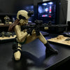A female tactical rifleman desktop figurine in a helmet and armor posing with a black assault rifle.