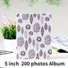 A white fabric memory album featuring a repeating pattern of black leaf silhouettes.