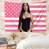 A woman with long dark hair wearing a black strapless top stands in front of a pink and white American flag tapestry on a bri