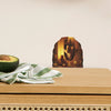 A cute mouse wall decal is displayed on a wooden surface next to an avocado and a green striped cloth.