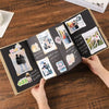 A handcrafted accordion photo album with various photos and handwritten notes is displayed on a wooden table.