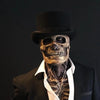 A realistic latex skull mask displayed on a mannequin wearing a black top hat and suit jacket.