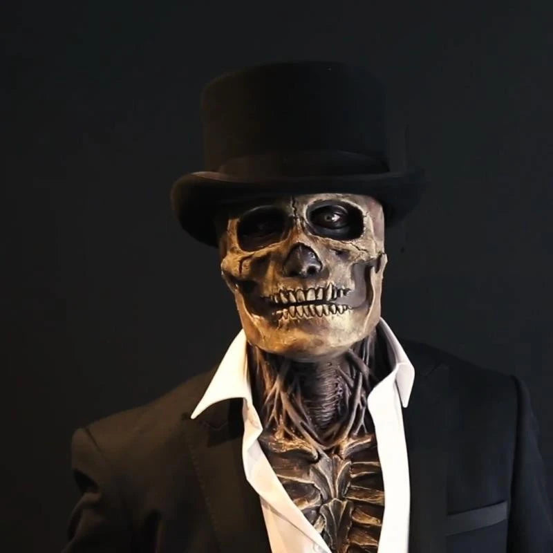 A realistic latex skull mask displayed on a mannequin wearing a black top hat and suit jacket.