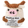 A handmade crochet mini cow plush toy with brown horns and pink face.