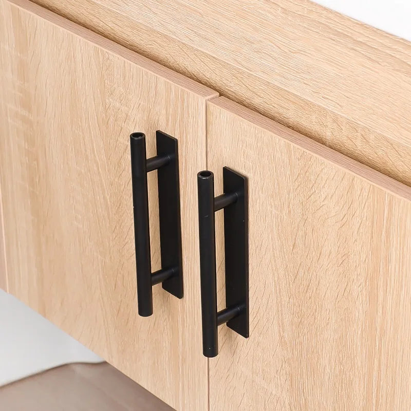 Two black self-adhesive cabinet handles installed on a light wood wardrobe door.