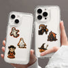 A hand holds a clear phone case featuring retro graffiti aesthetic stickers on the back.