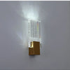 Modern bubble crystal LED wall sconces mounted on a gray wall, emitting a bright light.