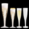 A set of clear plastic champagne flutes with gold rims and stems displayed against a black background.