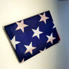 A navy blue decorative banner featuring white stars and pink accents, displayed on a light wall.