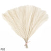 A bundle of light beige artificial pampas grass or reed bouquet with a pink ribbon tied at the bottom.
