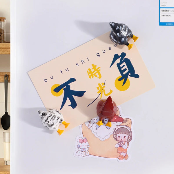 A set of three fridge magnets featuring a black and yellow chicken, a blue bird, and a character illustration.