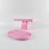 A pink cupcake stand with a tiered base and a pink serving plate.