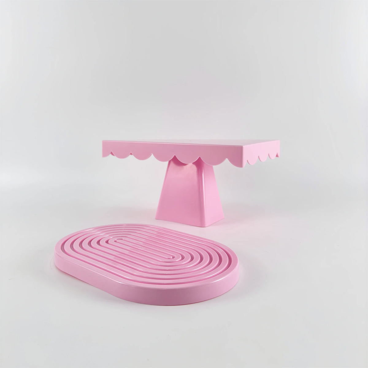 A pink cupcake stand with a tiered base and a pink serving plate.