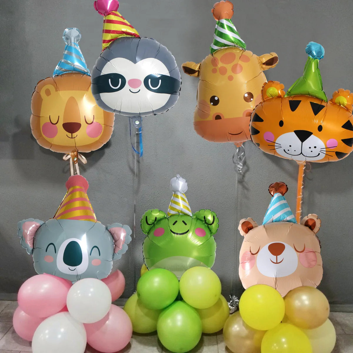 A collection of foil balloons shaped like various jungle animals including a elephant, lion, tiger, and bear.