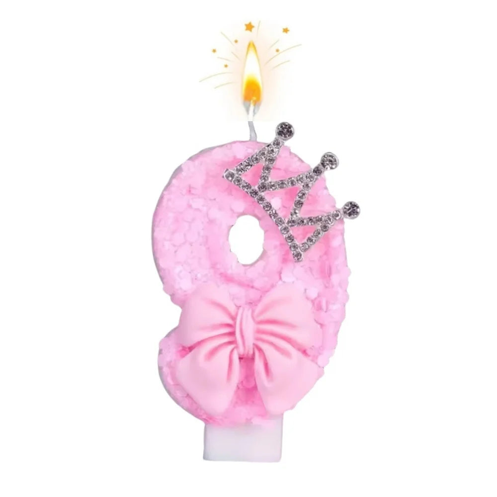 Pink bow crown number birthday candles set with a lit candle.
