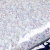 A close-up view of silver and iridescent resin rhinestones scattered on a surface.