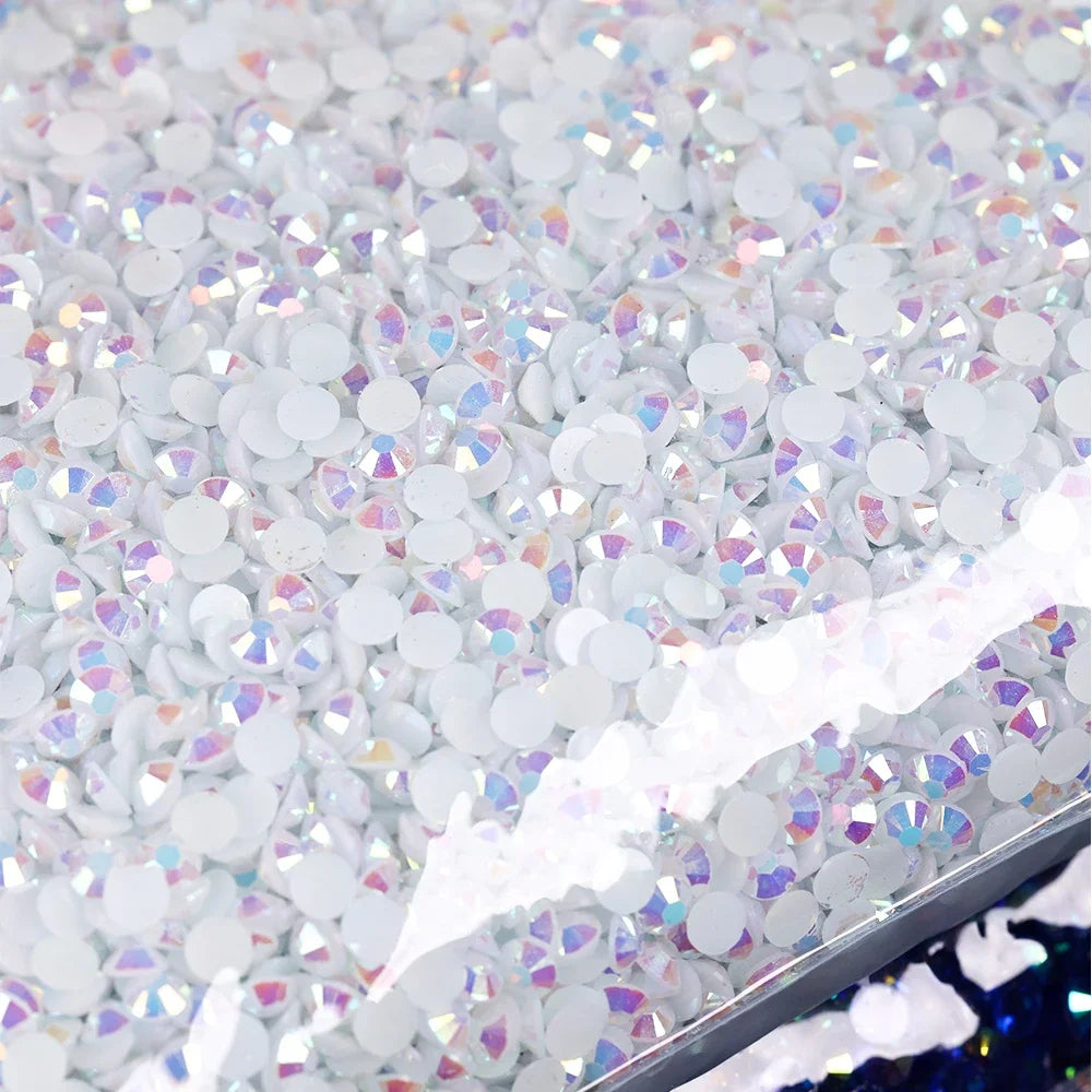 A close-up view of silver and iridescent resin rhinestones scattered on a surface.