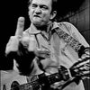 Foto en blanco y negro de Johnny Cash actuando, titulada At San Quentin.
