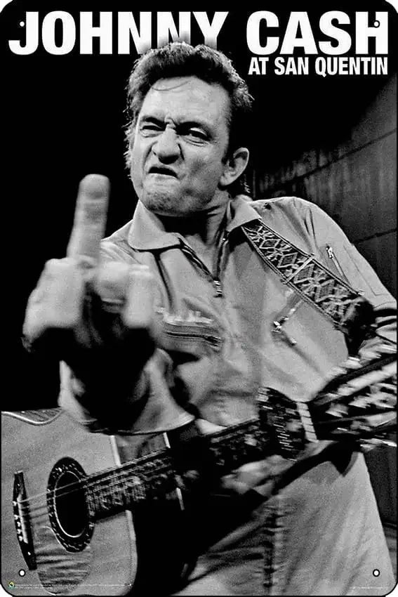 Foto en blanco y negro de Johnny Cash actuando, titulada At San Quentin.
