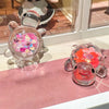 A collection of glow-in-the-dark mini sea turtle figurines in various colors and crafts displayed on a pink surface.