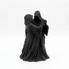 A dark romantic sculpture depicting a couple in hooded cloaks.