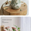 A rustic ceramic milk pitcher with a cracked glaze and pastoral design, shown in various contexts.