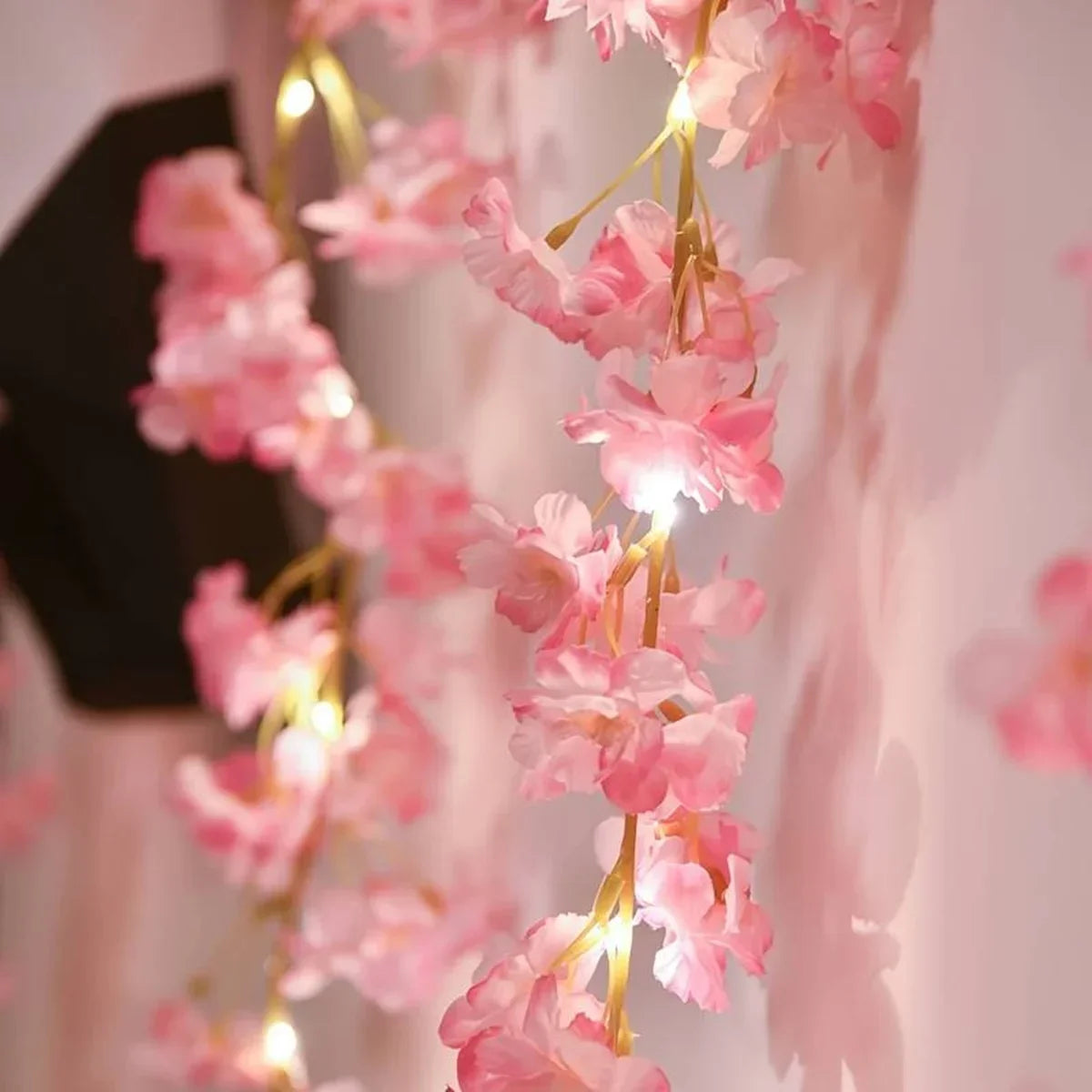 Pink cherry blossom string lights garland hanging in soft light
