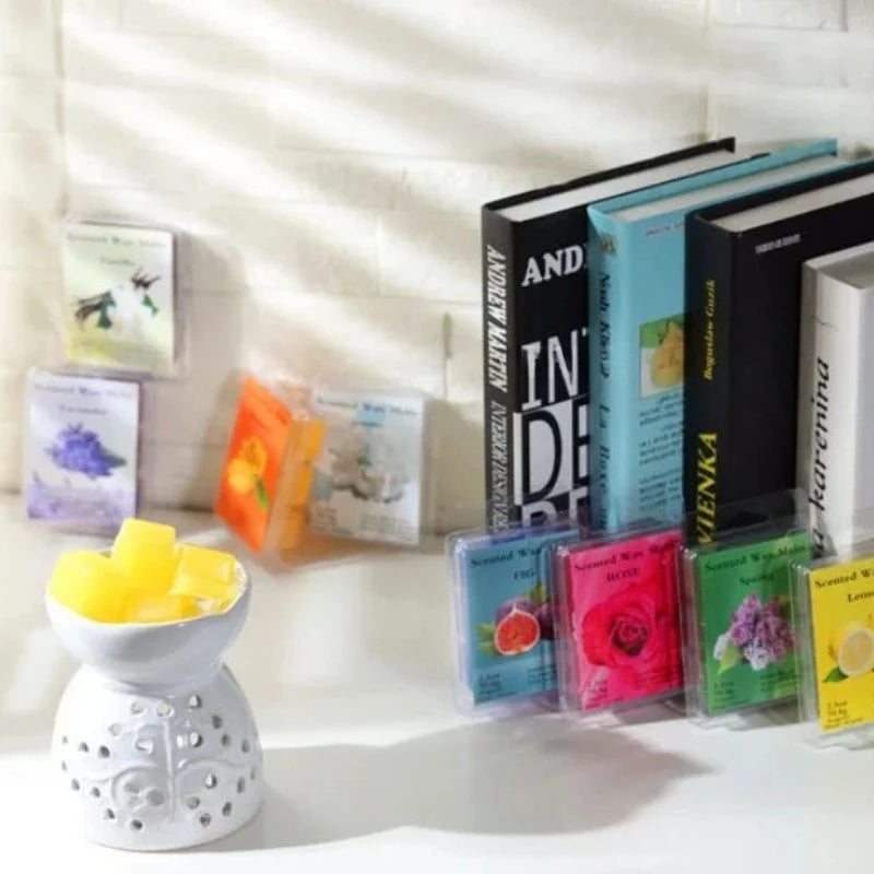 A collection of aromatic essential oil wax blocks and books for DIY candle making displayed on a white surface.