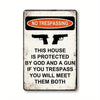 A vintage warning sign with the text NO TRESPASSING and a message about being protected by God and a gun.