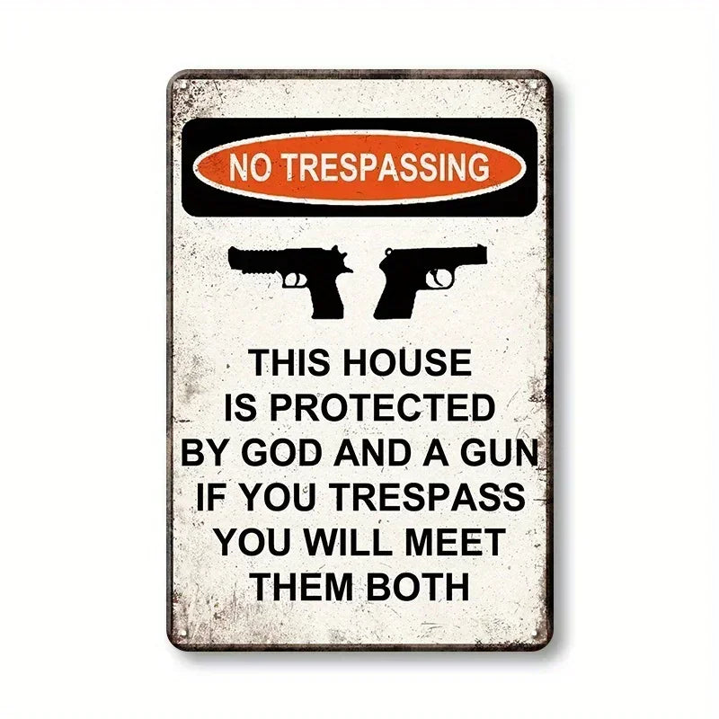 A vintage warning sign with the text NO TRESPASSING and a message about being protected by God and a gun.