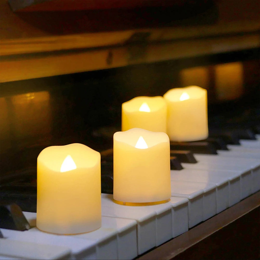 Several glowing white LED tea light candles are placed on a piano keyboard with a dark background.
